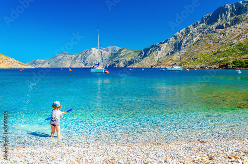 Sea bay on Greek Island with small boy at play