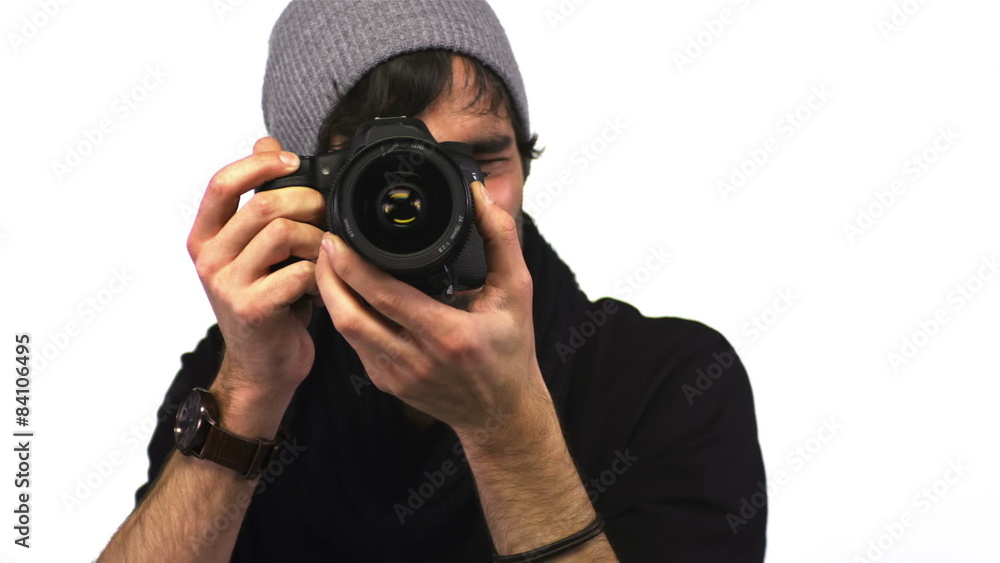 A cute make photographer looks at the camera while taking pictures A cute make photographer looks at the camera while taking pictures