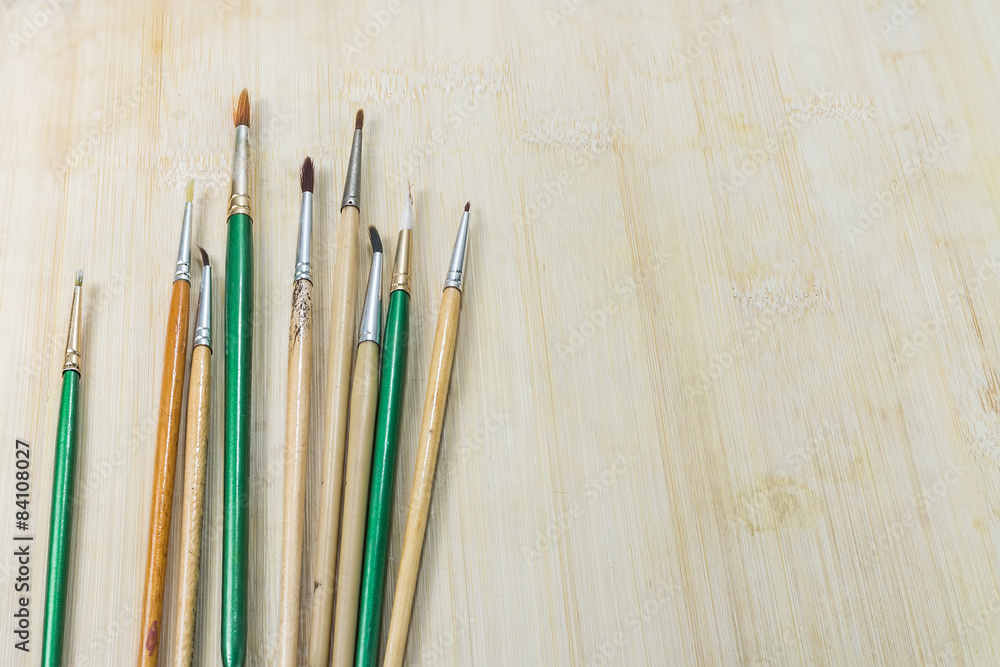 Obraz premium Used artist paintbrushes on wood background