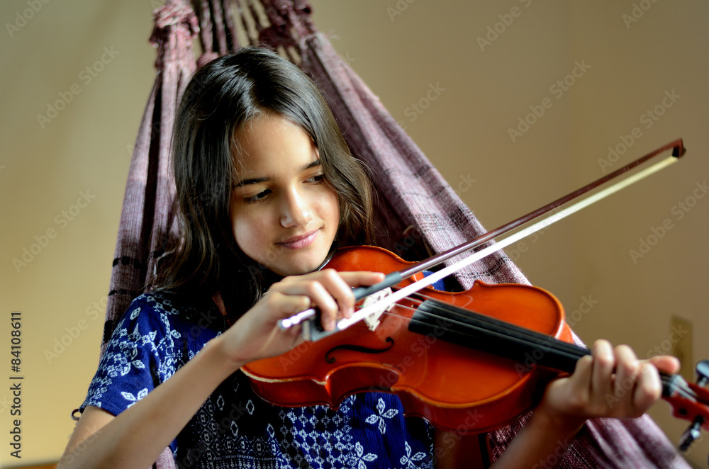 Little Hispanic girl practices the violin in a hammock Little Hispanic girl practices the violin in a hammock