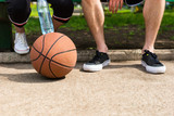 Basketball at Feet of Couple Sitting on Park Bench