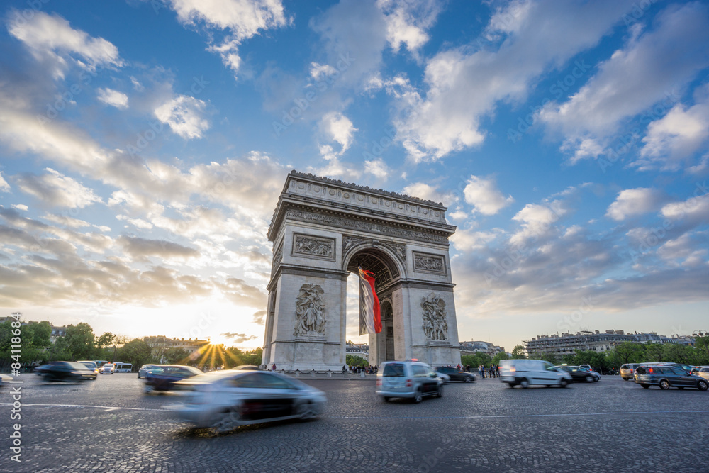 Fototapeta premium Arc de Triomphe and blurred traffic at sunset