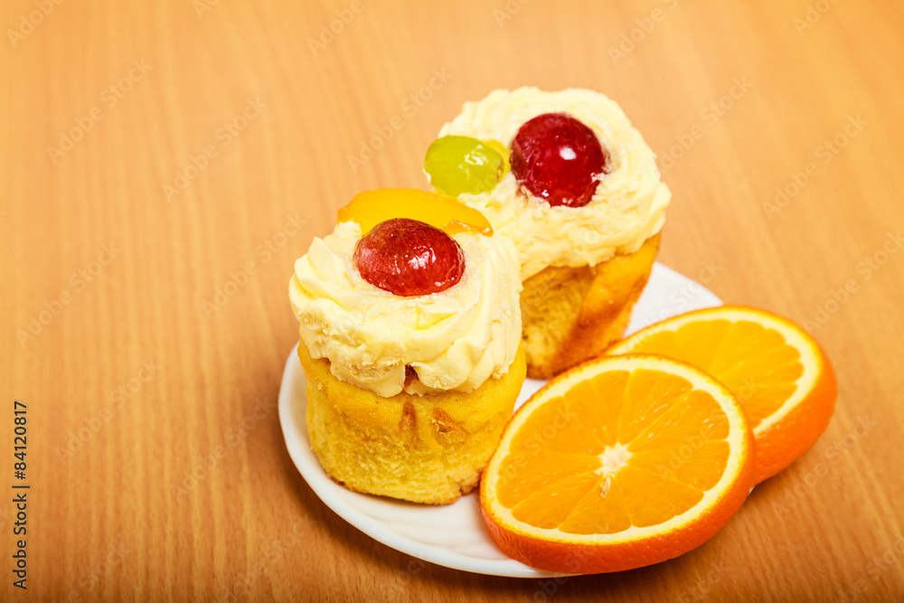 Gourmet cream cake cookie and orange on plate