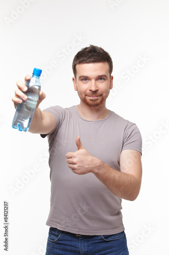 smiling young man showing water bottle