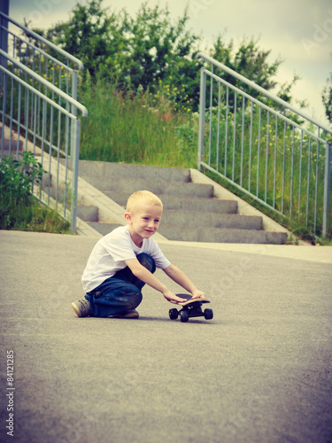 Sporty child kid with his skateboard outdoor.