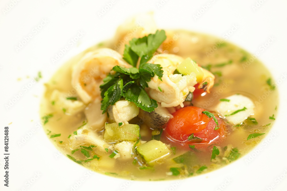 soup with fish, tomatoes, zucchini, herbs