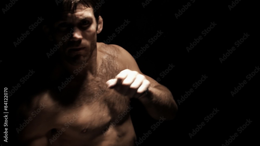 Athlete stands in front of camera and shadow boxes without any gloves on Athlete stands in front of camera and shadow boxes without any gloves on
