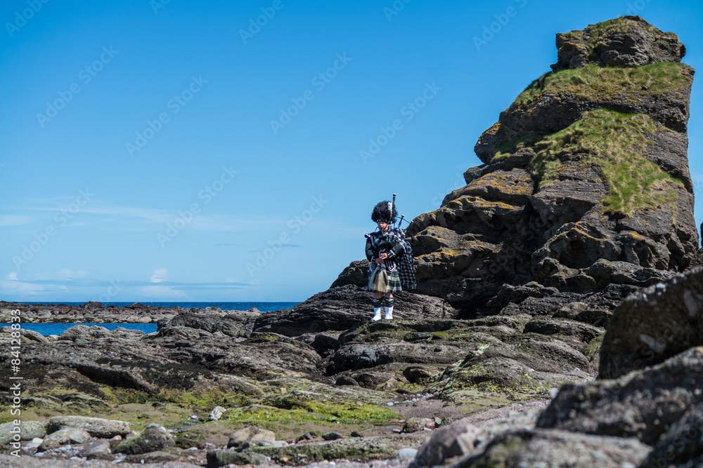 Traditional bagpiper in the scottish highlands near Pennan