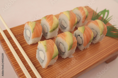 sushi with salmon and avocado on wooden plate photo