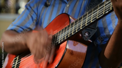 A man plays guitar on the street for money