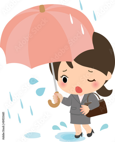 雨の中を通勤するスーツの女性