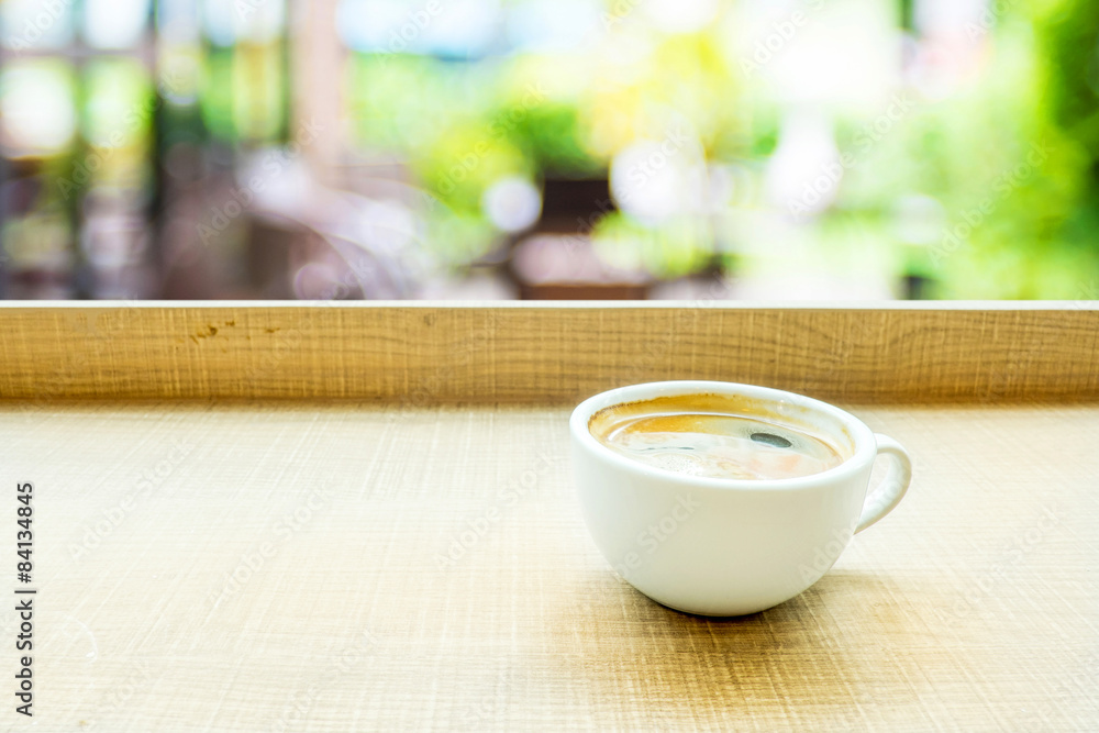 Espresso Coffee cup on wood table in cafe with blur green garden Espresso Coffee cup on wood table in cafe with blur green garden