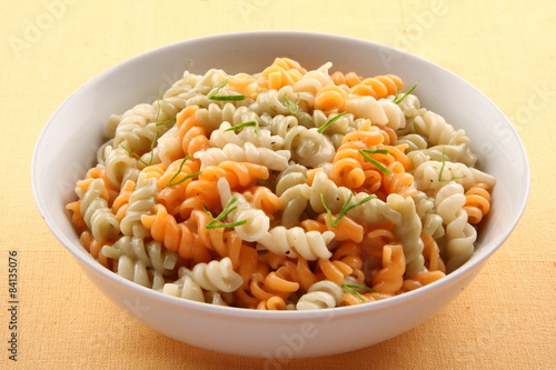 Colour pasta in white bowl.