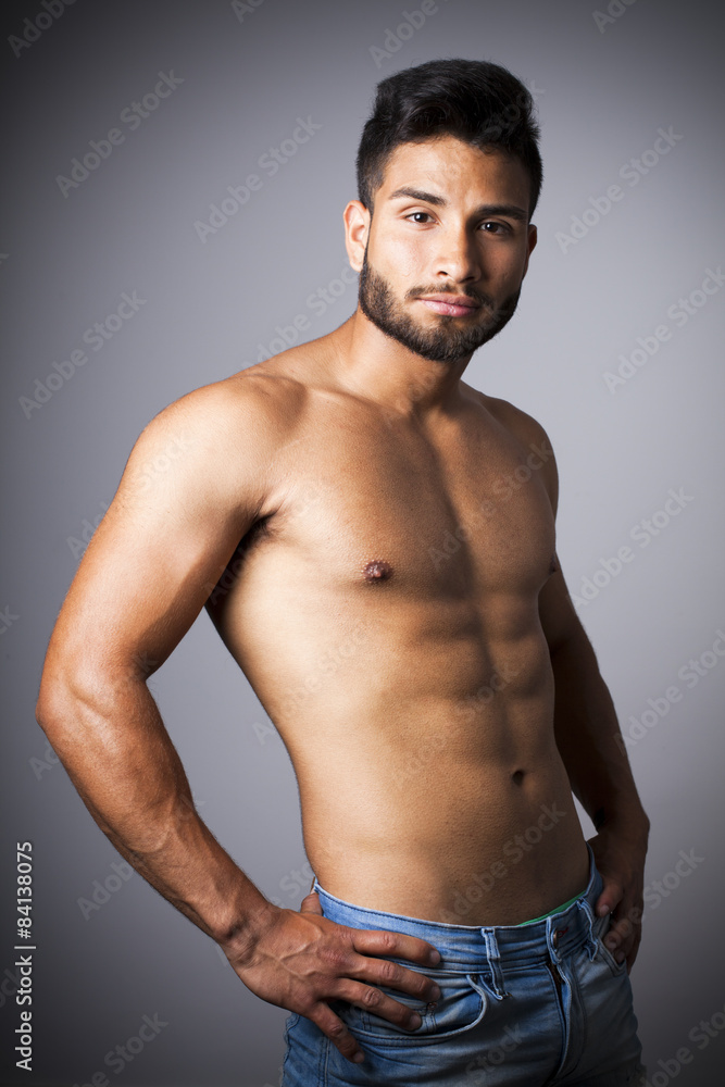 Hombre latino con torso desnudo y pantalones vaqueros