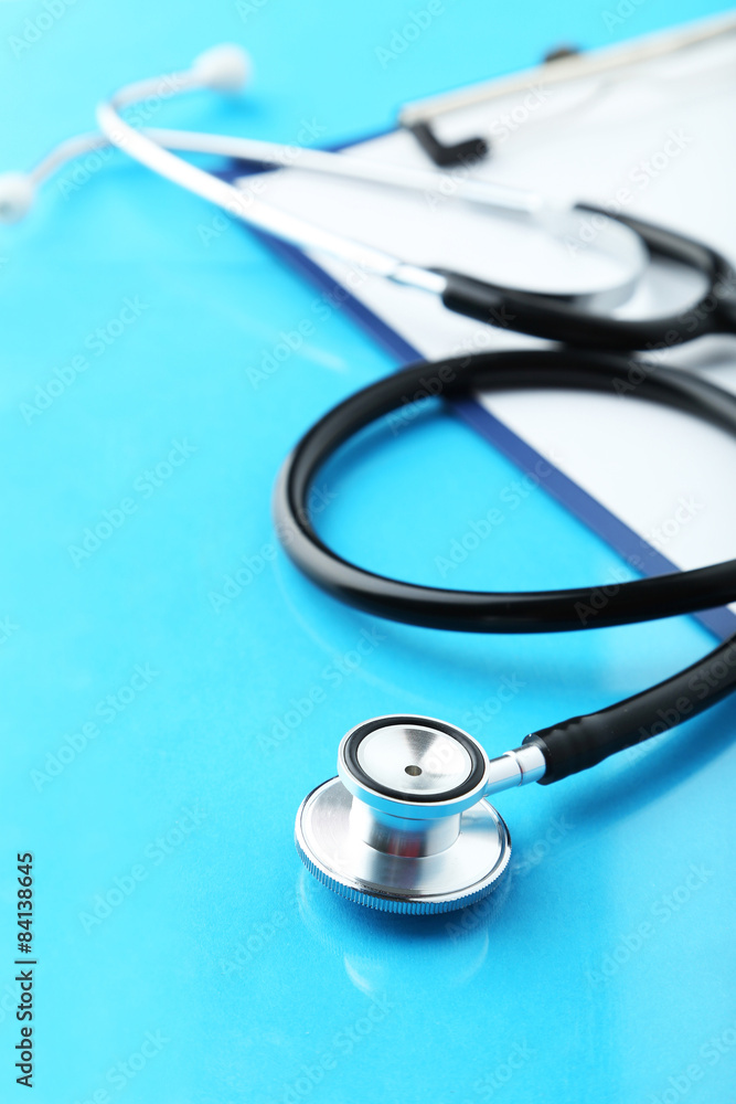 Stethoscope with tablet for notes on blue background Stethoscope with tablet for notes on blue background