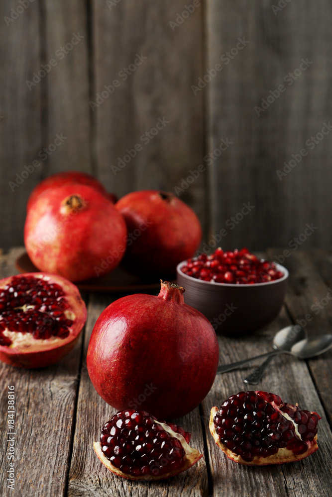 Delicious pomegranate fruit on grey wooden background Delicious pomegranate fruit on grey wooden background