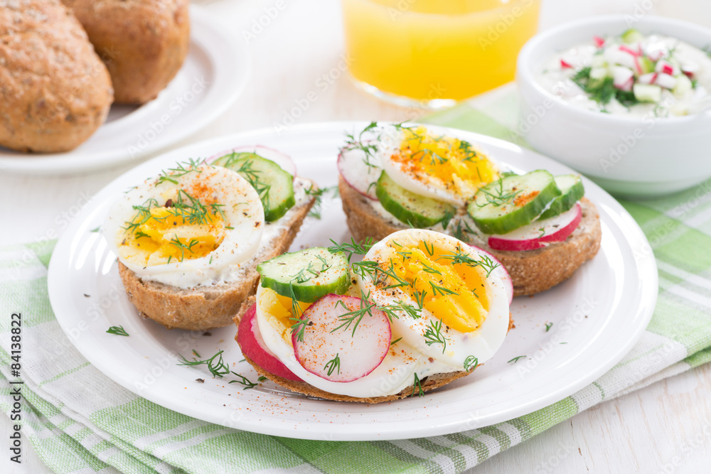 buns with egg and vegetables on plate for breakfast
