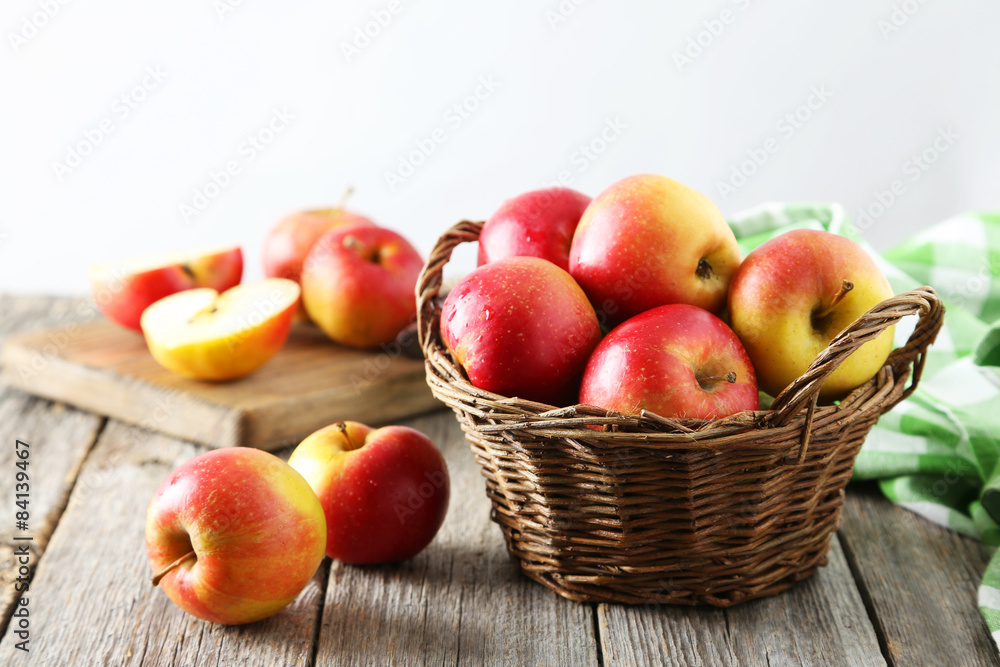 Red apples in basket on grey wooden background Red apples in basket on grey wooden background