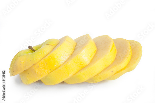 Single yellow apple cut into diagonal slices