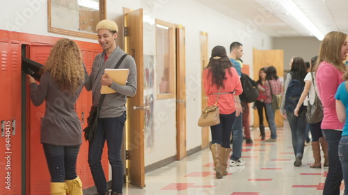 Students stand next to their lockers and then hurry to get to their next class photo