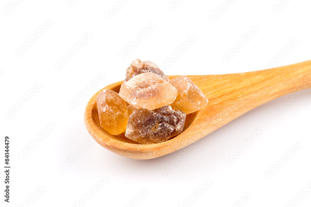 brown caramelized sugar in a wooden spoon brown caramelized sugar in a wooden spoon