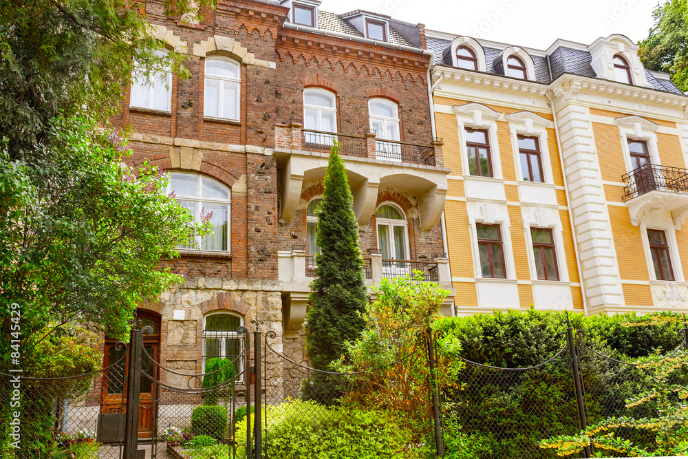 Fototapeta premium facade of the old brick building of the forged fence