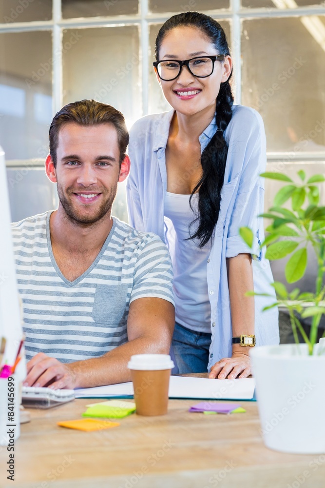 Obraz premium Smiling partners working together on computer