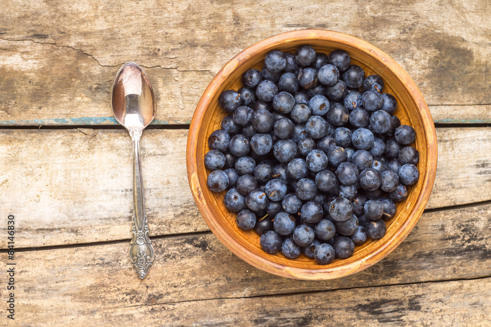 Clay bowl with fresh wild berries on wooden background Clay bowl with fresh wild berries on wooden background