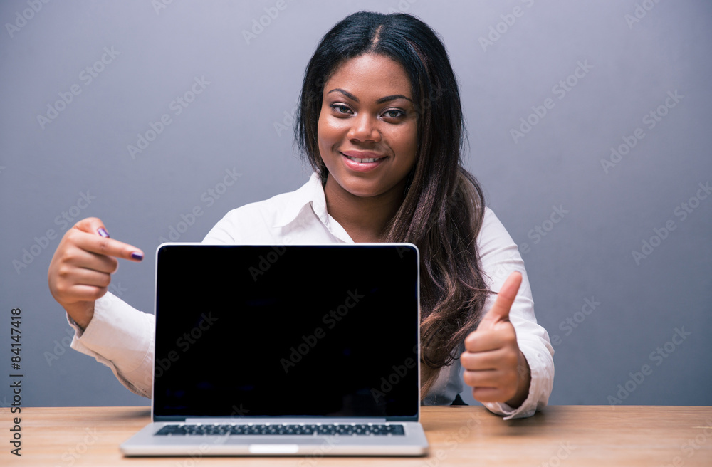 Businesswoman pointing on blank laptop screen Businesswoman pointing on blank laptop screen