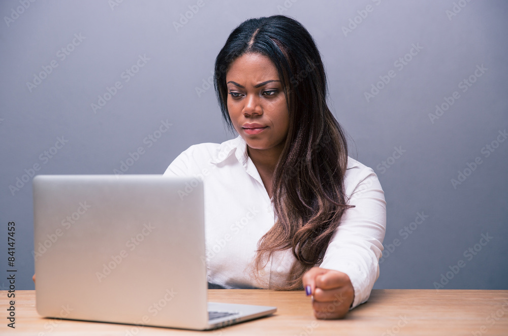 Angry african businesswoman using laptop Angry african businesswoman using laptop