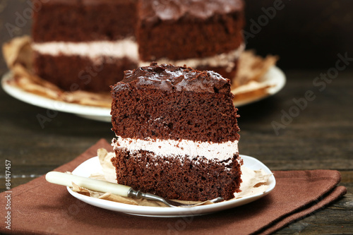 Delicious chocolate cake on table on brown background