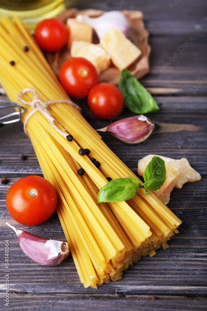 Raw pasta with cheese and vegetables on wooden background Raw pasta with cheese and vegetables on wooden background