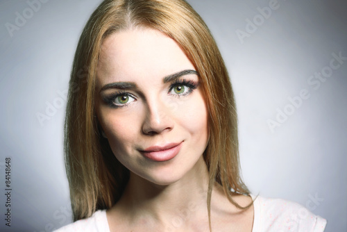 Portrait of beautiful young woman on gray background