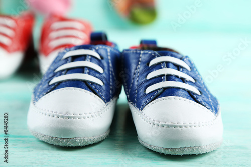 Colorful toddler shoes on wooden background