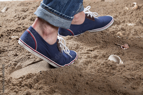 Man's Legs And Footprint On The Sand