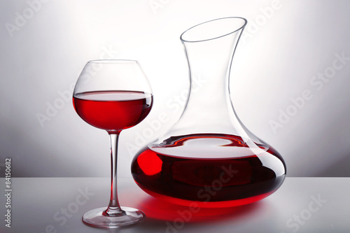 Glass carafe of wine on light background