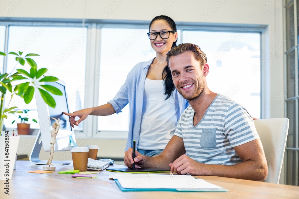 Obraz premium Smiling partners working together on computer and digitizer