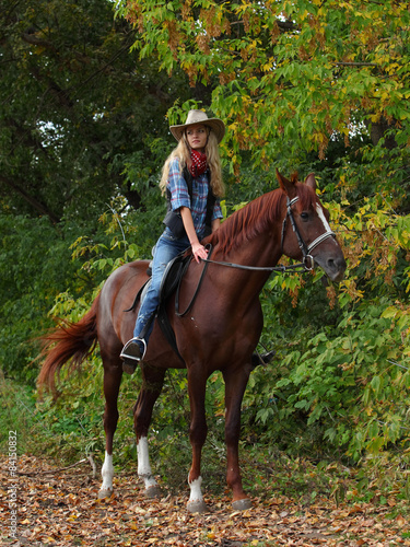 Cowgirl relaxing with horse in the forest
