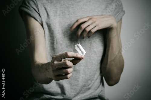 man holding a razor to suicide in the studio