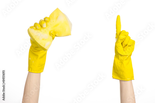 Hand holding a yellow sponge wet with foam in studio gloves