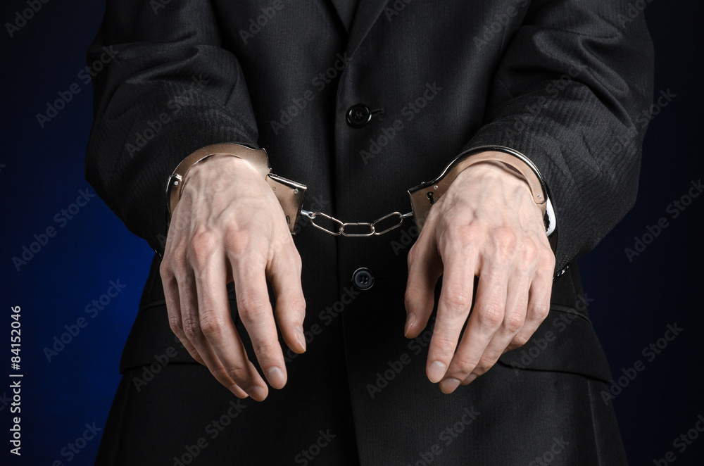 businessman in a black suit with handcuffs on his hands studio businessman in a black suit with handcuffs on his hands studio
