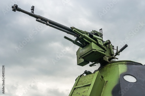 Detail of cannon tube (machine gun) and armored military vehicle