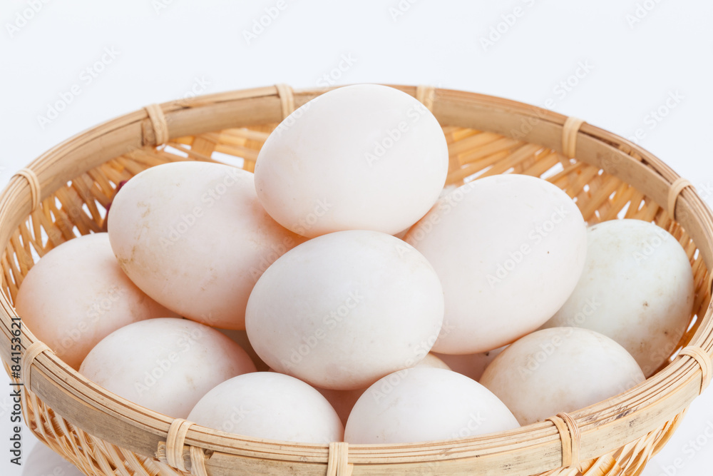 Raw dirty duck eggs in the bamboo bowl basket on white backgroun Raw dirty duck eggs in the bamboo bowl basket on white backgroun