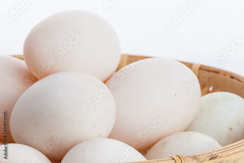 Raw dirty duck eggs in the bamboo bowl basket on white backgroun