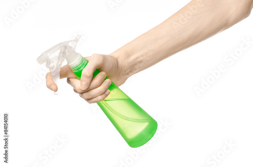 man's hand holding a green spray bottle for cleaning