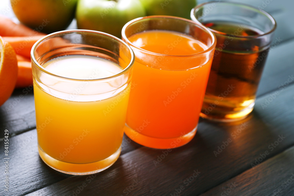 Assortment of healthy fresh juices and fruits on wooden table background Assortment of healthy fresh juices and fruits on wooden table background