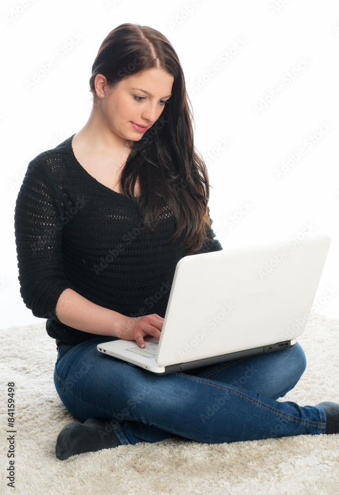 Frau sitzt auf dem Boden und chattet am Laptop Frau sitzt auf dem Boden und chattet am Laptop