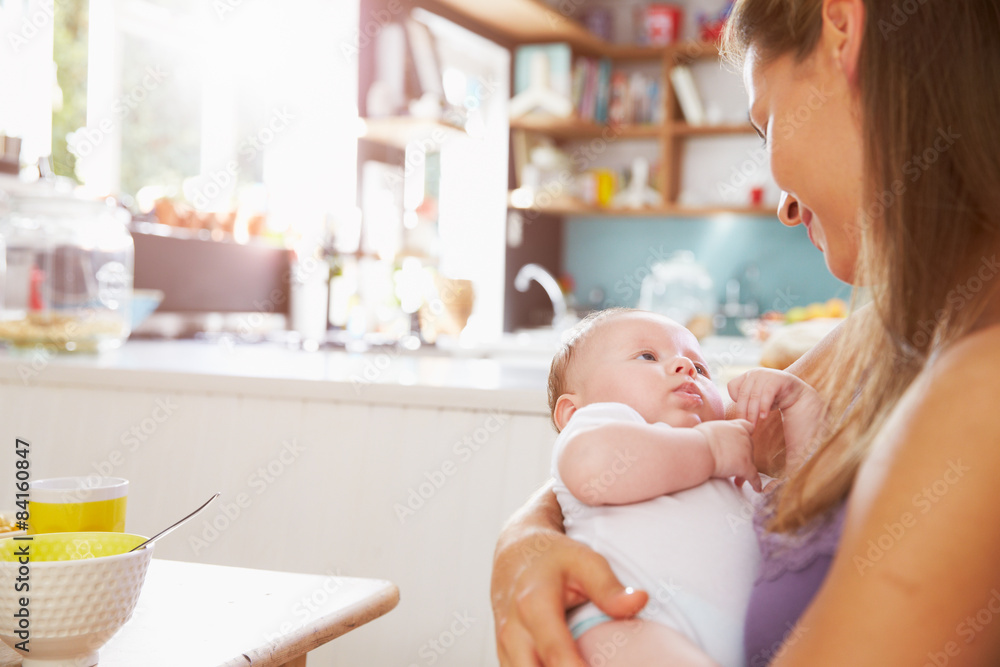 Mother Holding Newborn Baby Daughter At Kitchen Table Mother Holding Newborn Baby Daughter At Kitchen Table