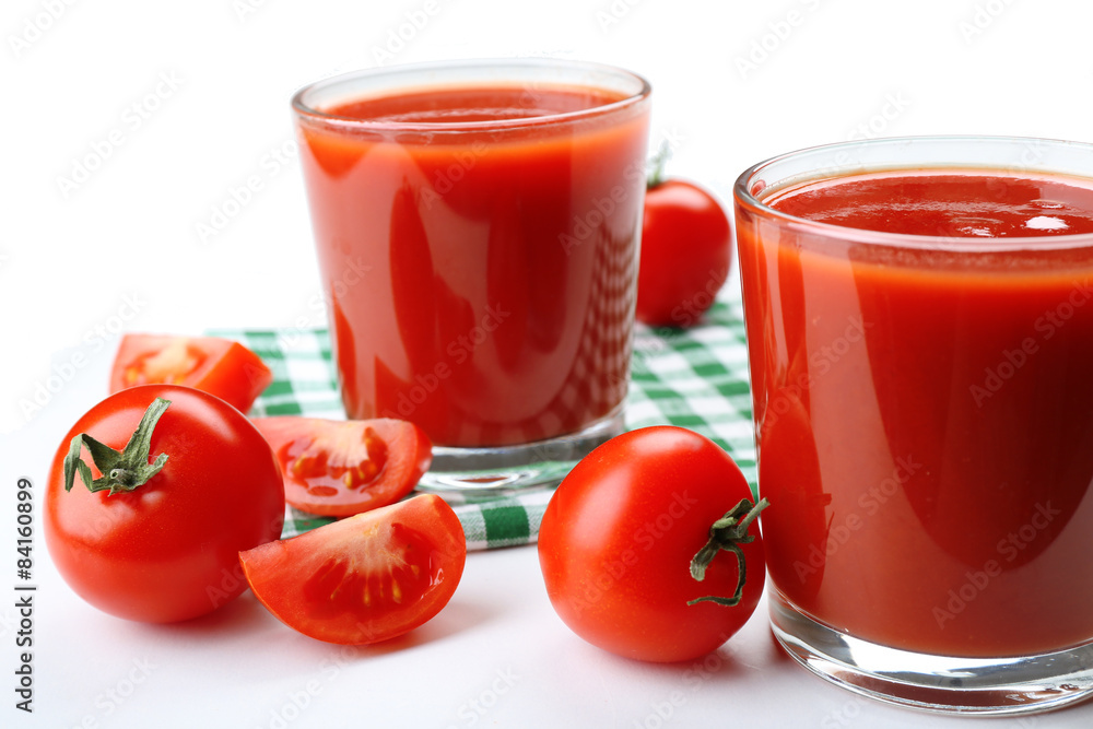 Glasses of fresh tomato juice on checkered napkin, isolated on white Glasses of fresh tomato juice on checkered napkin, isolated on white