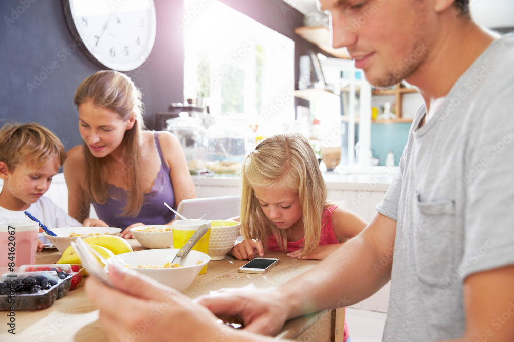 Obraz premium Family Using Digital Devices At Breakfast Table